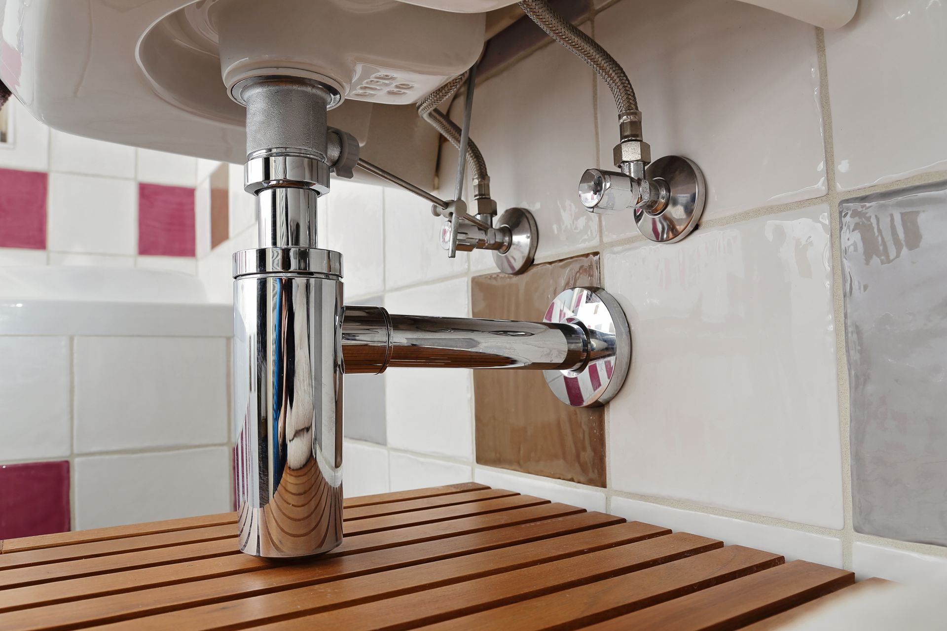 Un plombier répare des toilettes dans une salle de bain.