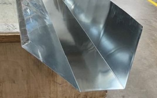 Conduits métalliques inclinés reposant sur une surface en bois.