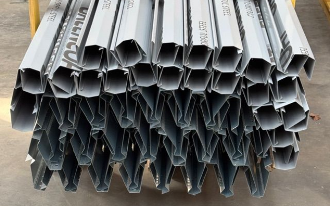 Pile de montants métalliques galvanisés à profil en zigzag, prêts pour la construction.