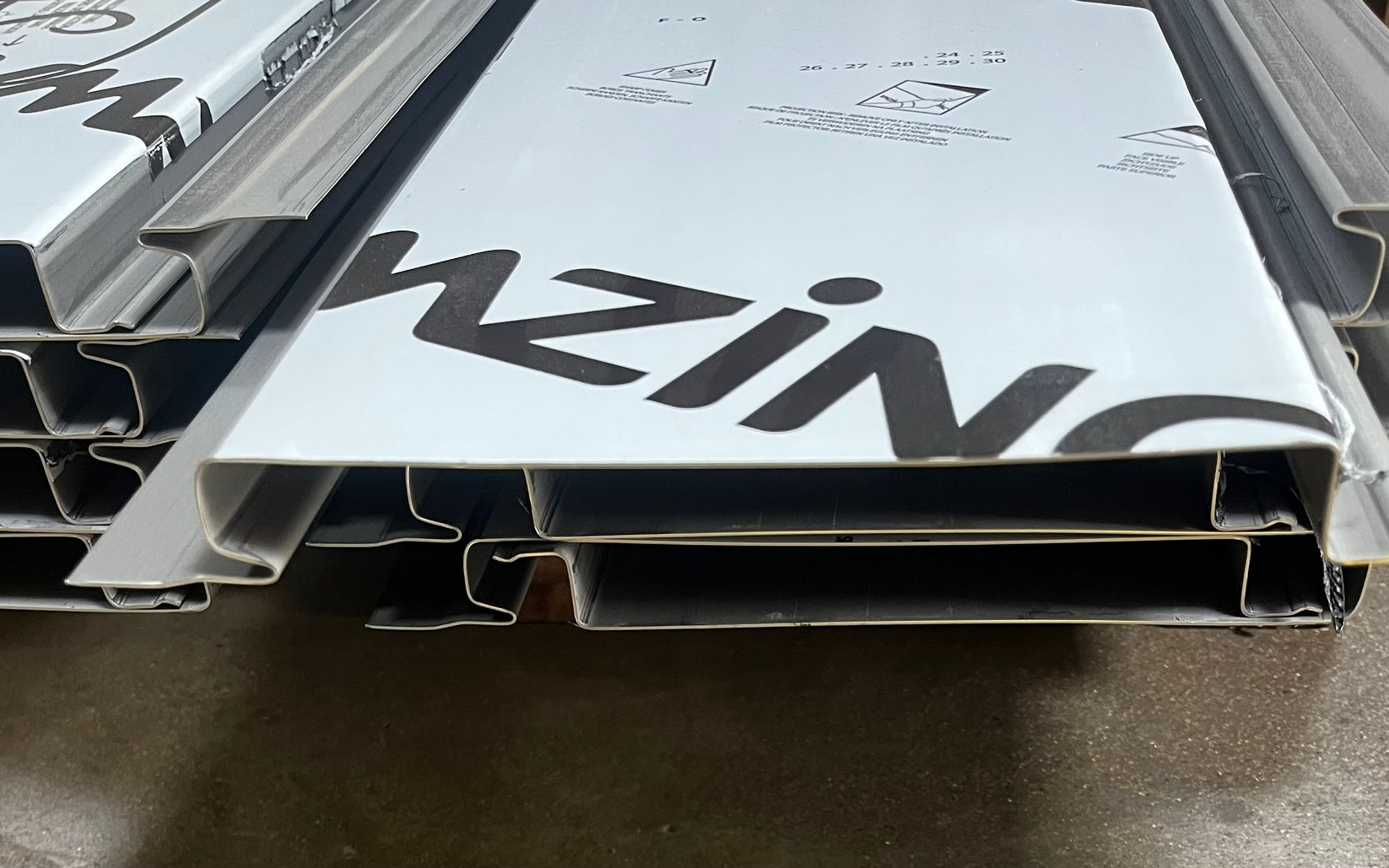 Panneaux métalliques empilés, avec le logo « Nzing » imprimé sur le panneau supérieur.