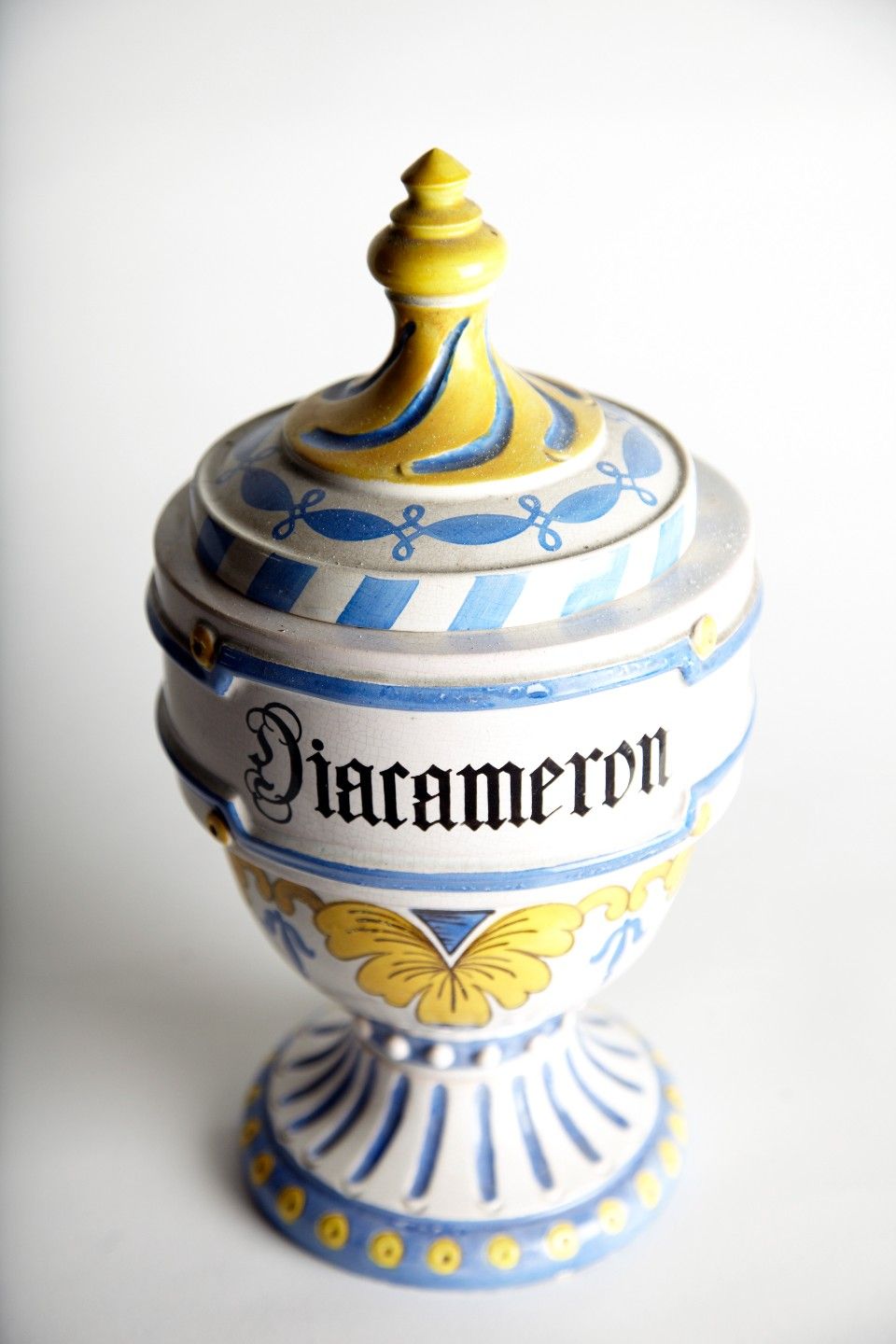 Keramisches Apothekergefäss, verziert mit blauen und gelben Akzenten, mit der Aufschrift „Diacameron“.
