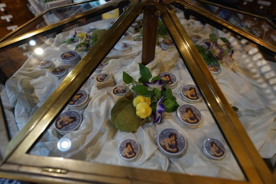 Vitrine mit runden Kunstwerken und Blumen.