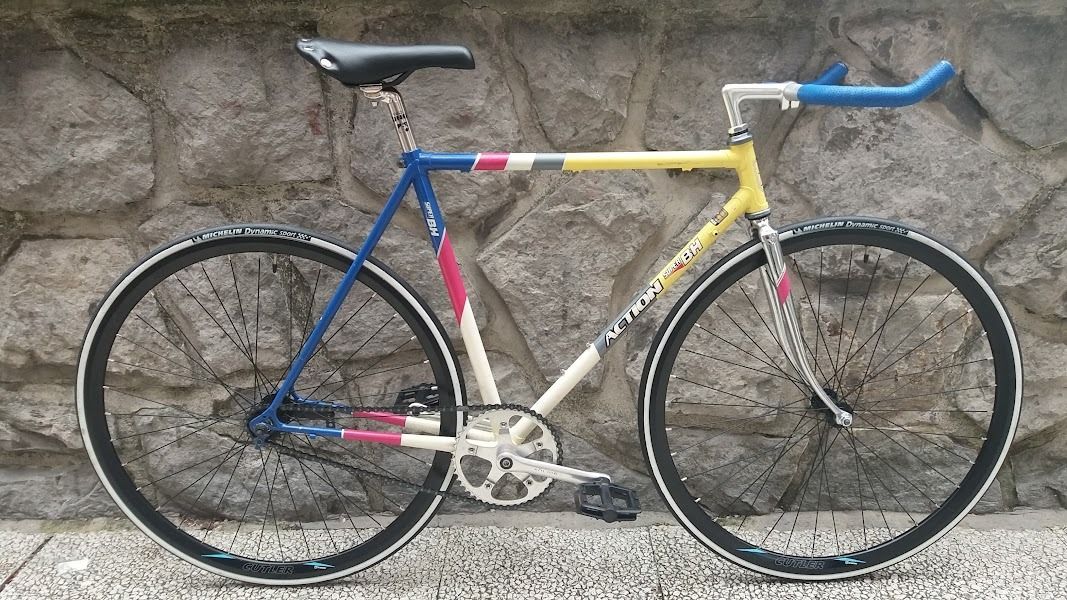 Una bicicleta colorida está estacionada frente a un muro de piedra.