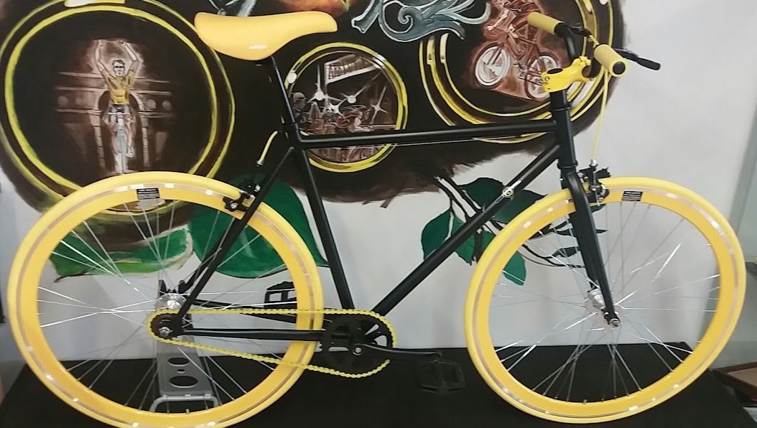 Una bicicleta negra con ruedas amarillas y un asiento amarillo