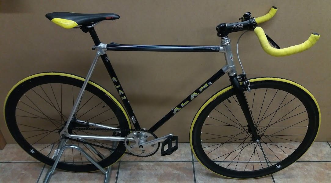Una bicicleta negra y amarilla con manillar amarillo