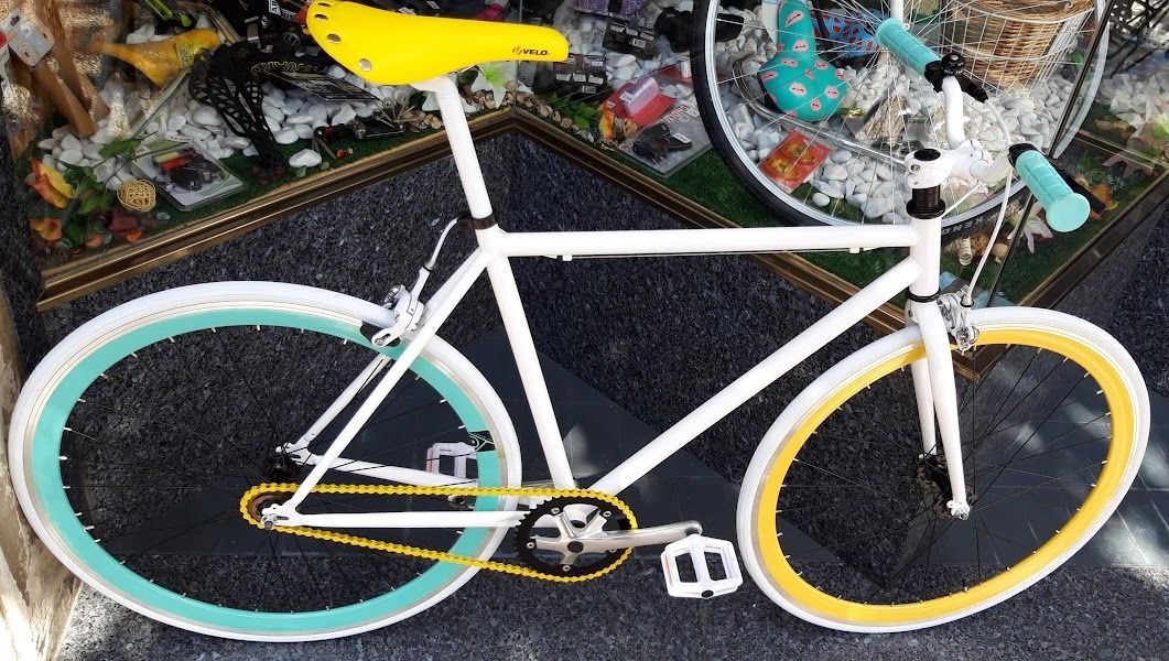 Una bicicleta blanca con ruedas amarillas y un asiento amarillo