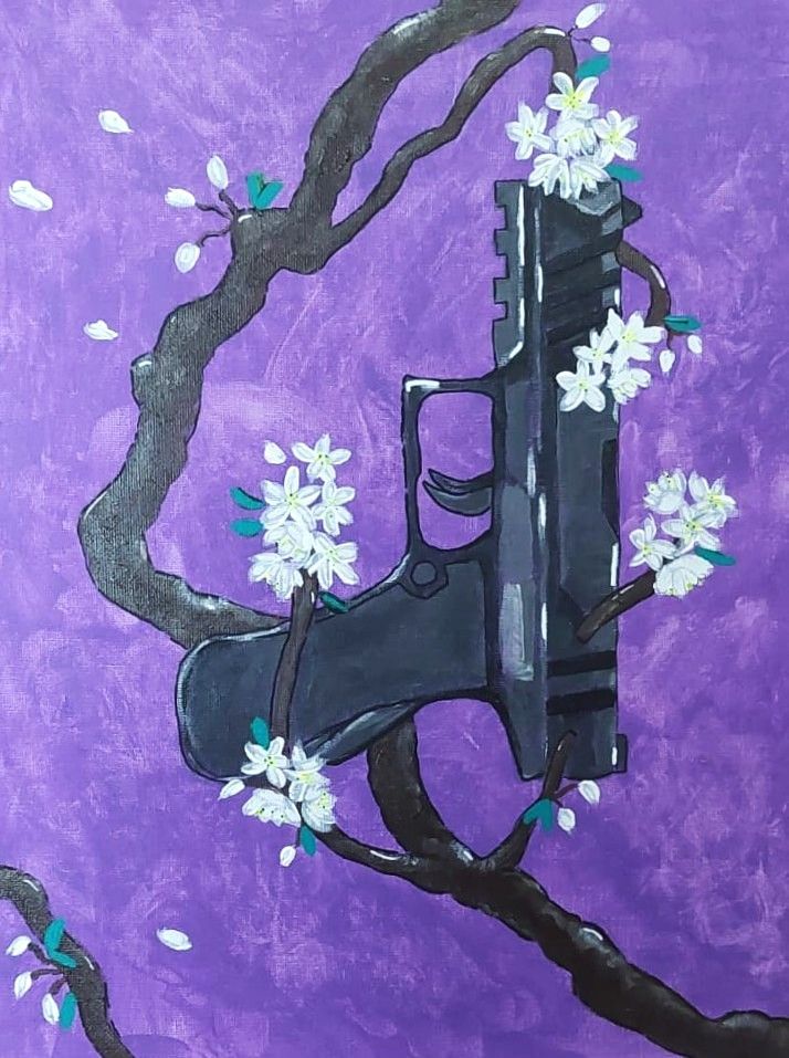 Una pistola negra con flores blancas sobre un fondo morado.