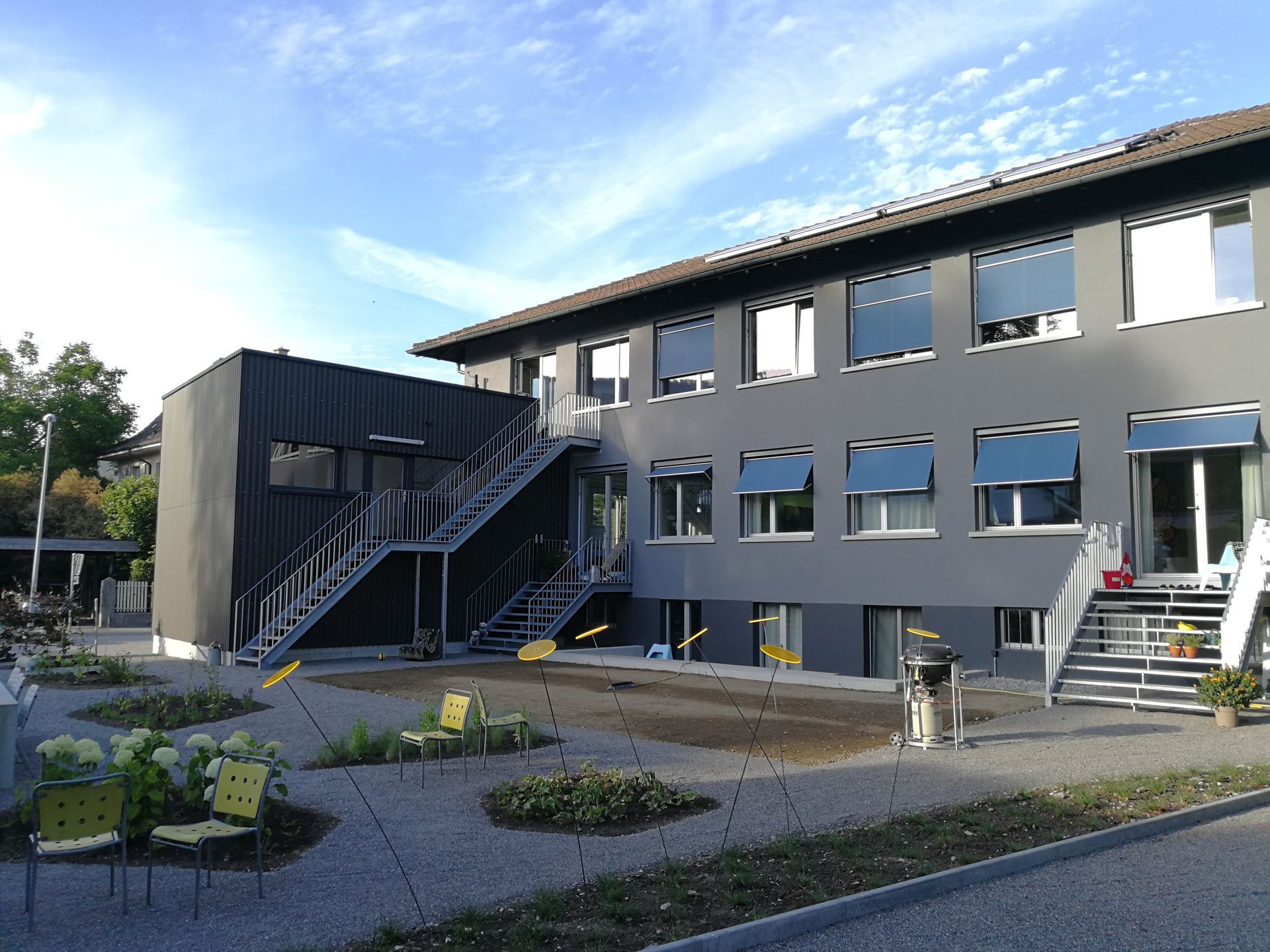 Ein Mann fährt mit dem Fahrrad eine Strasse vor einem Gebäude entlang. Foto von der b. müller's architekten ag
