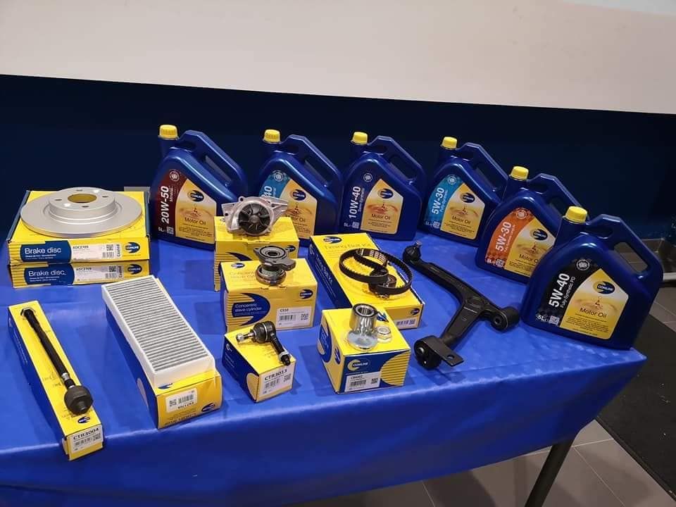 Una mesa cubierta con una variedad de piezas de automóviles y botellas de aceite.