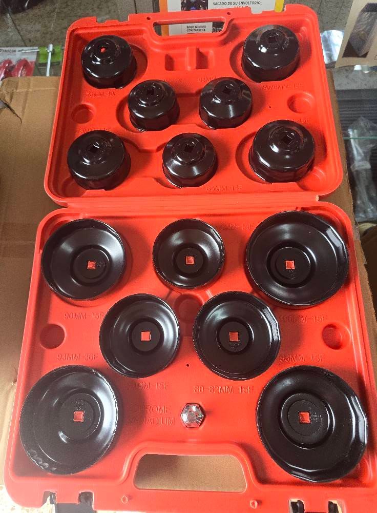 Una caja roja llena de arandelas negras está sobre una mesa.