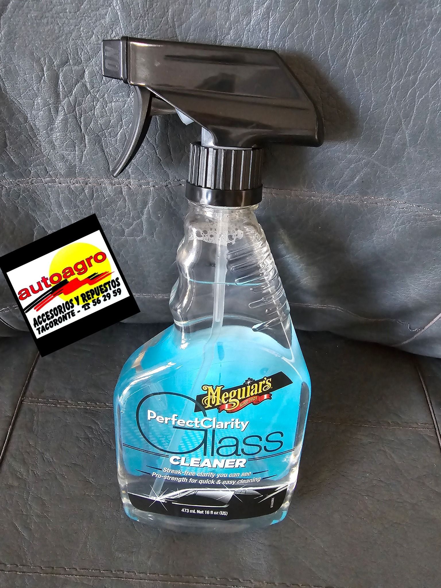 Una botella de limpiador de vidrios está sobre un sofá.