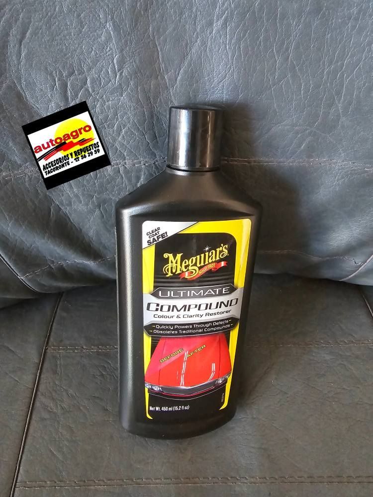 Una botella de cera premium Ultimate de Meguiar's está sobre un sofá.