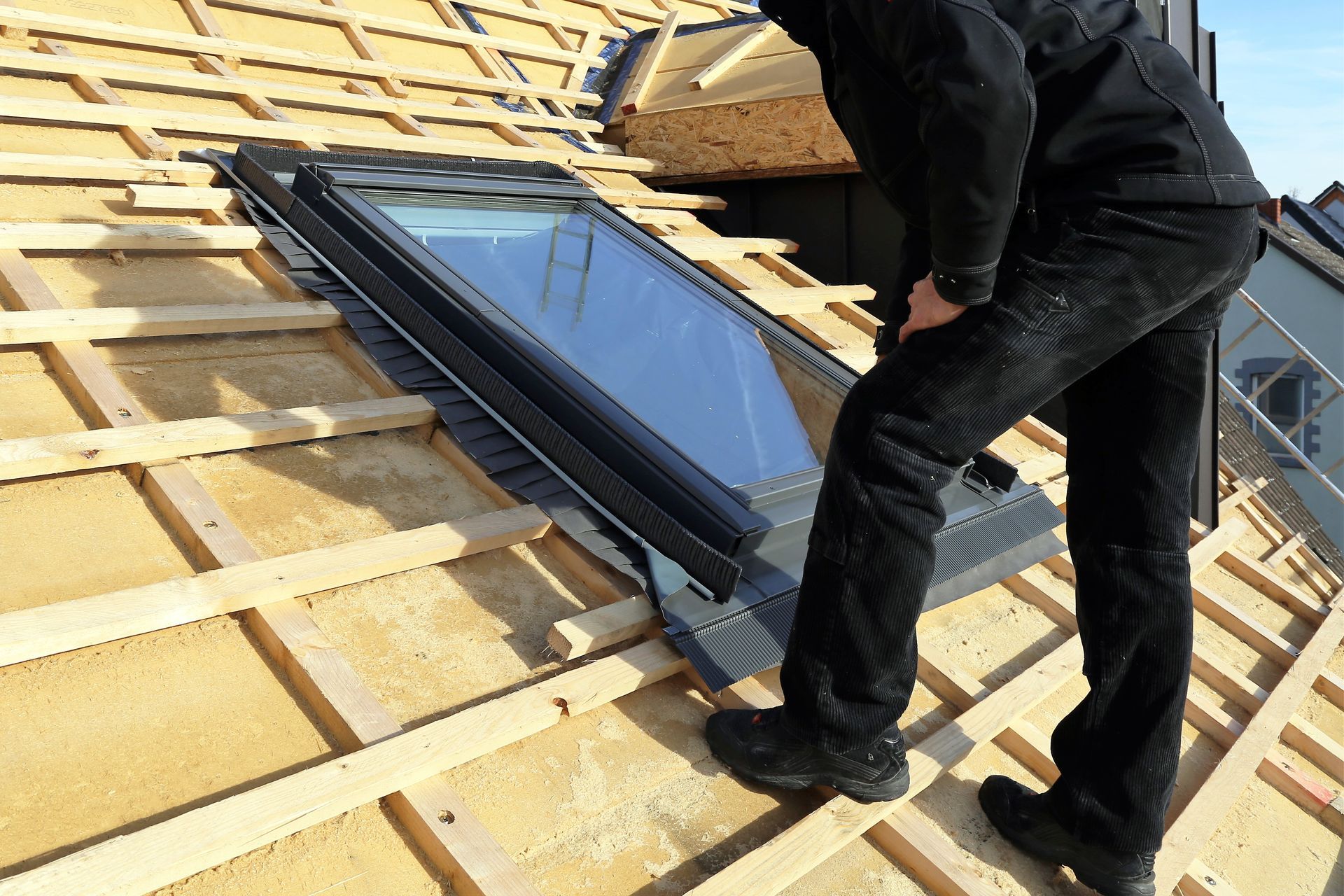 Professionnel de la toiture qui installe un Velux