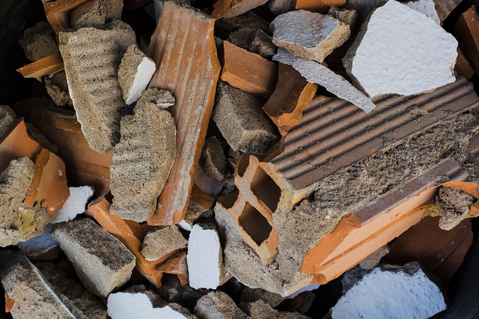 Tas de briques cassées et de gravats de béton avec des morceaux orange et gris