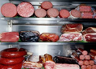 Un refrigerador lleno de una variedad de carnes y embutidos.