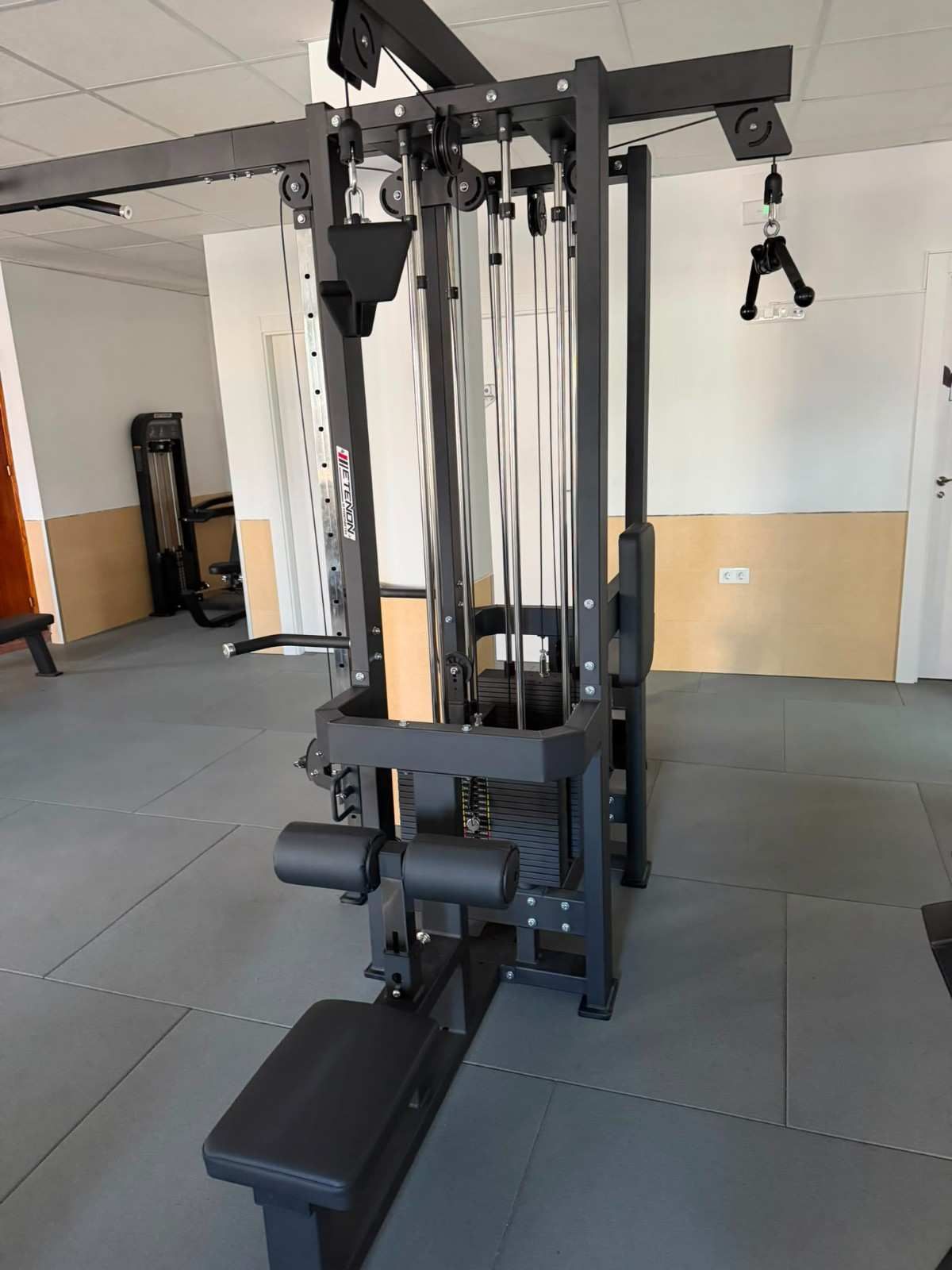 Máquina de poleas con banco en un gimnasio luminoso