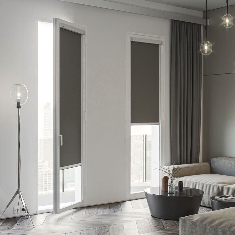Una sala de estar con un sofá, una mesa y dos ventanas.
