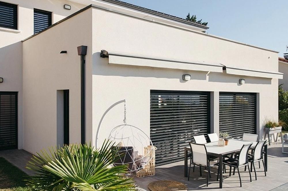 Una casa blanca con un área de patio con mesa y sillas.