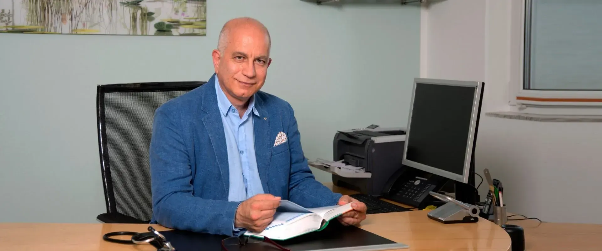 Ein Mann sitzt an einem Schreibtisch vor einem Computer.