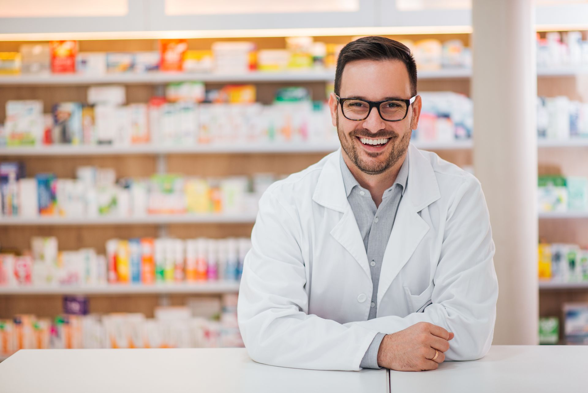 Pharmacien qui porte des lunettes avec un large sourire