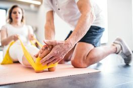 Physiotherapeut behandelt die Füße einer Frau