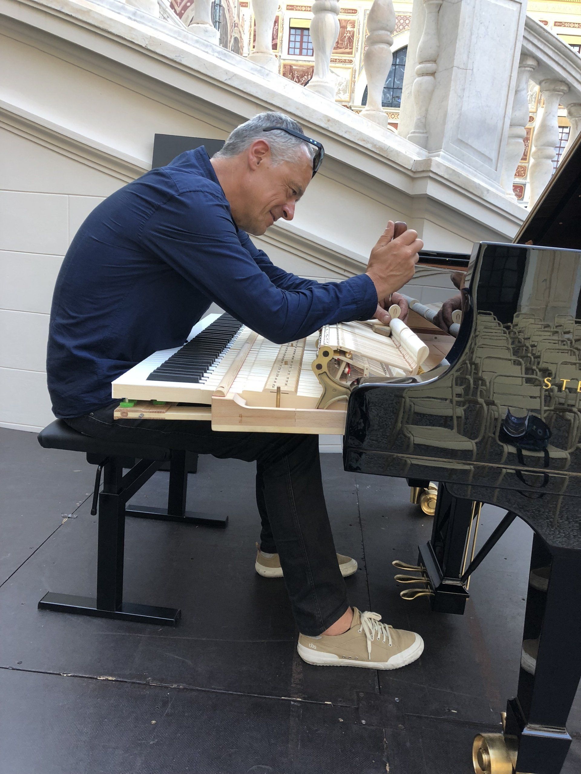 Un homme est assis devant un piano et travaille dessus
