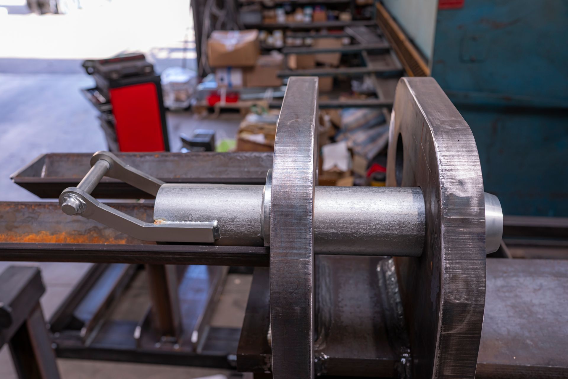 Dans un atelier, une goupille en acier fixe deux plaques métalliques, un levier permettant de les libérer.