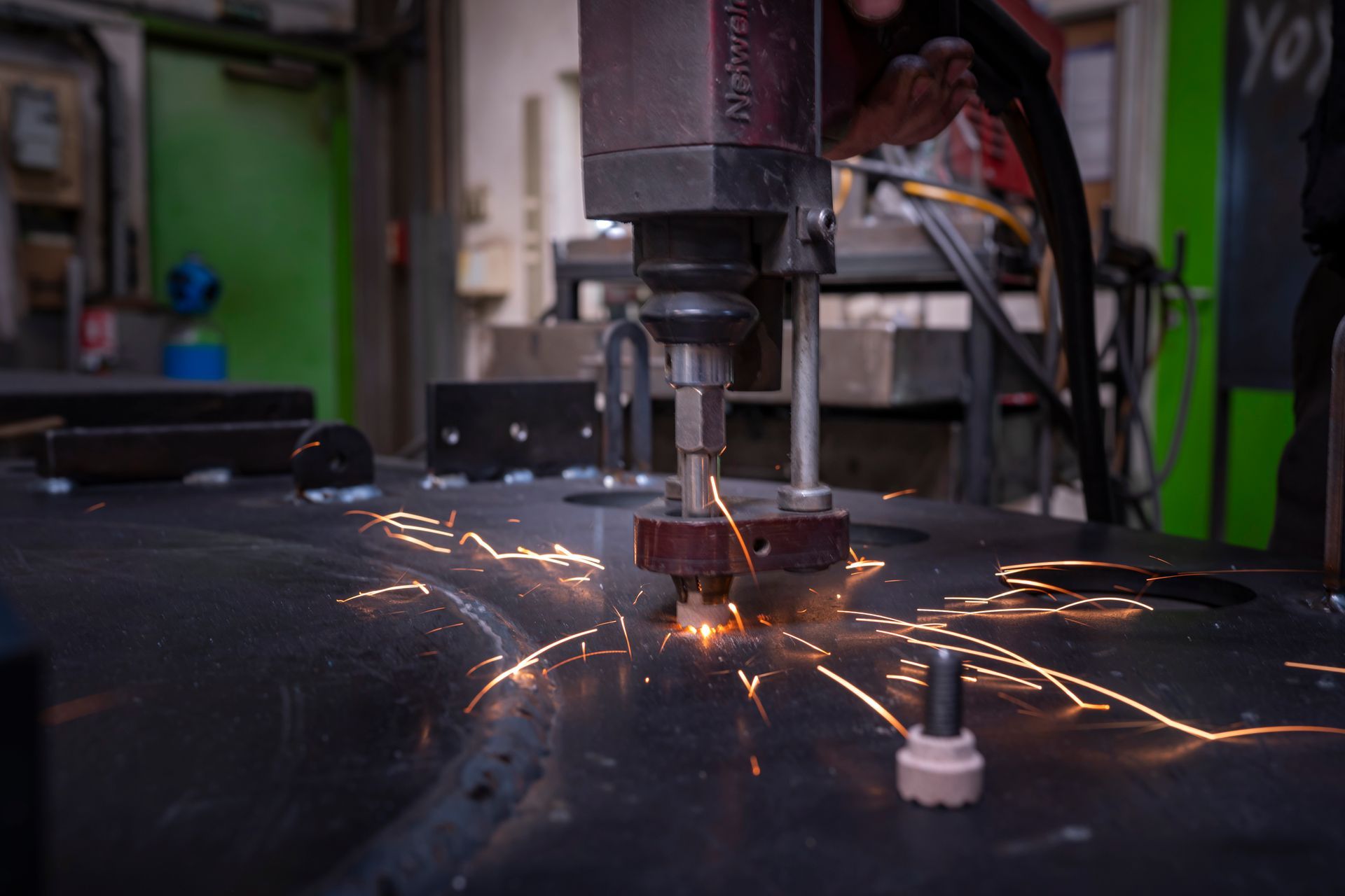 Des étincelles jaillissent d'une machine à découper les métaux lors de la découpe d'une tôle dans un atelier.