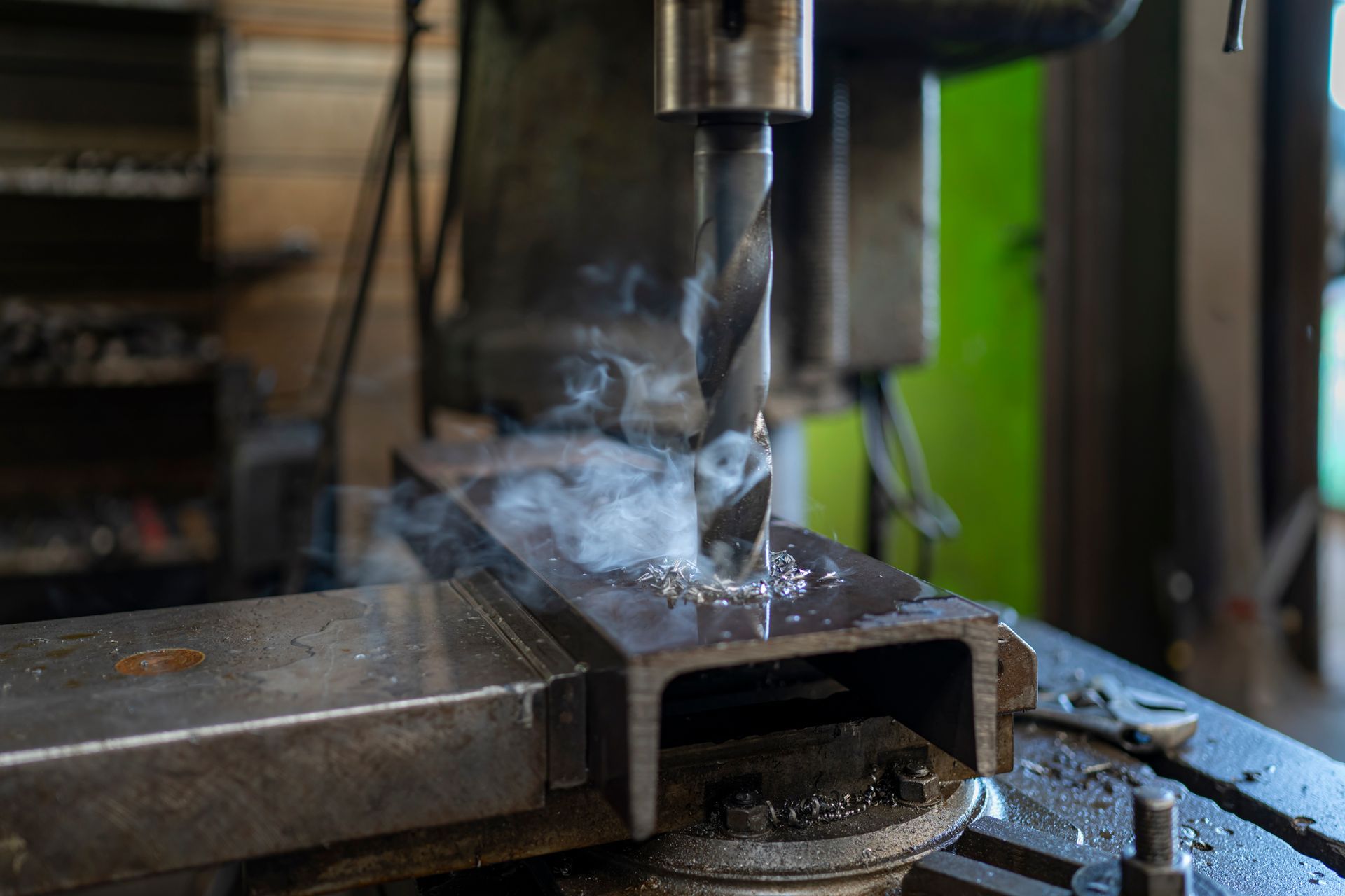 Réservoir industriel noir dans un atelier. Outils et équipements visibles en arrière-plan.