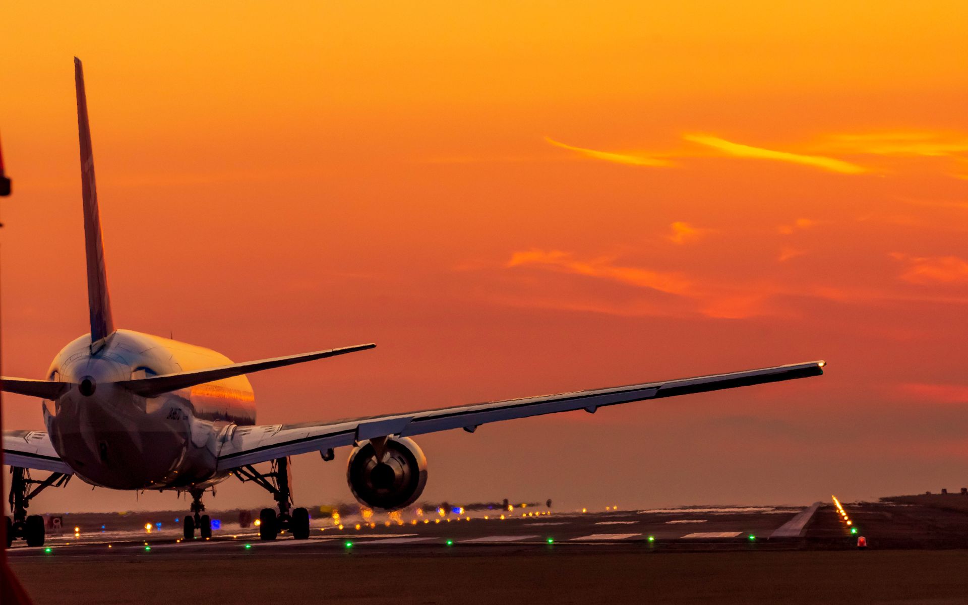 Avion sur une piste lors d'un couché de soleil.