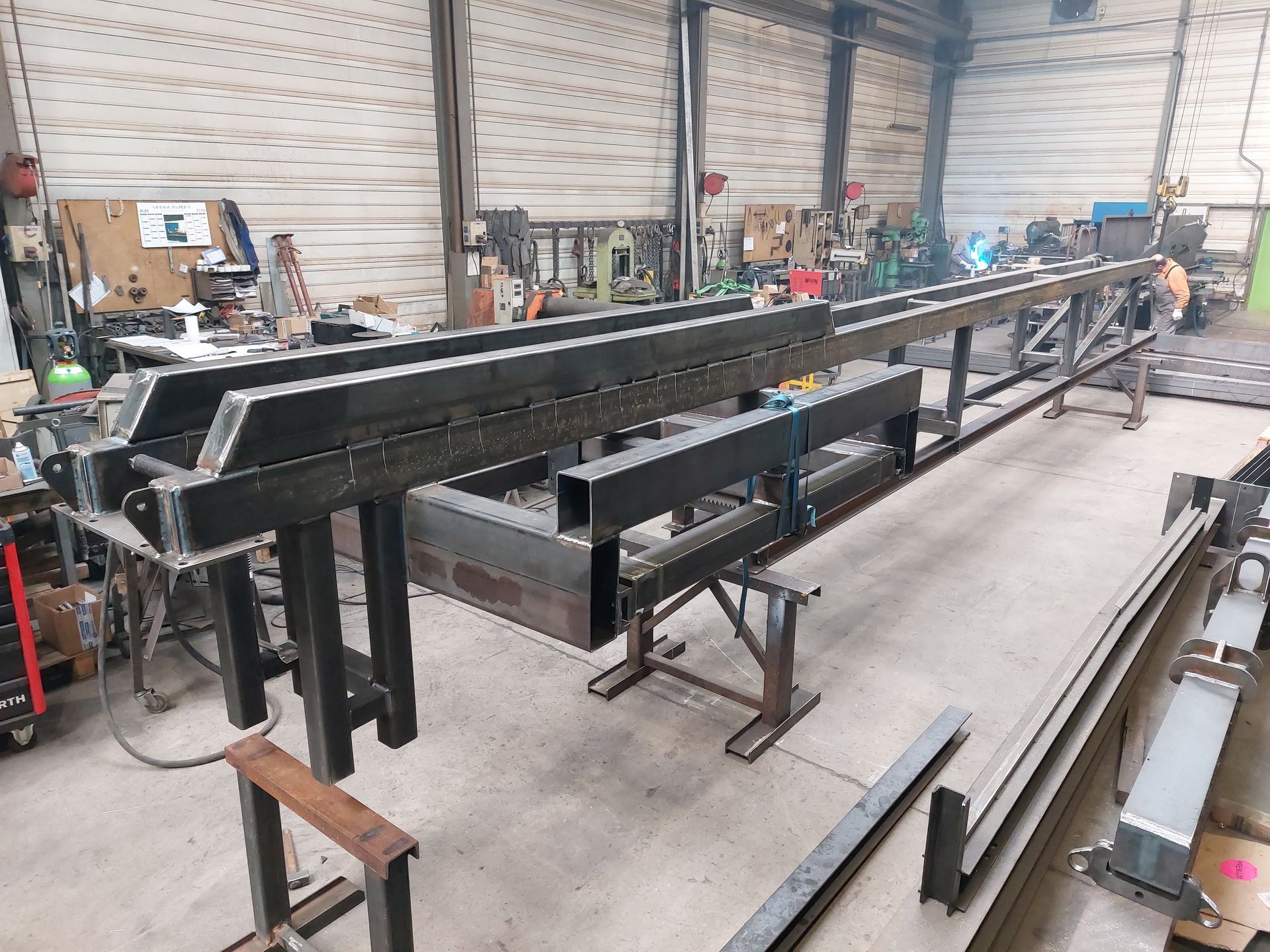 Structure métallique dans un atelier, construite avec des poutres soudées, soutenue par des tréteaux.