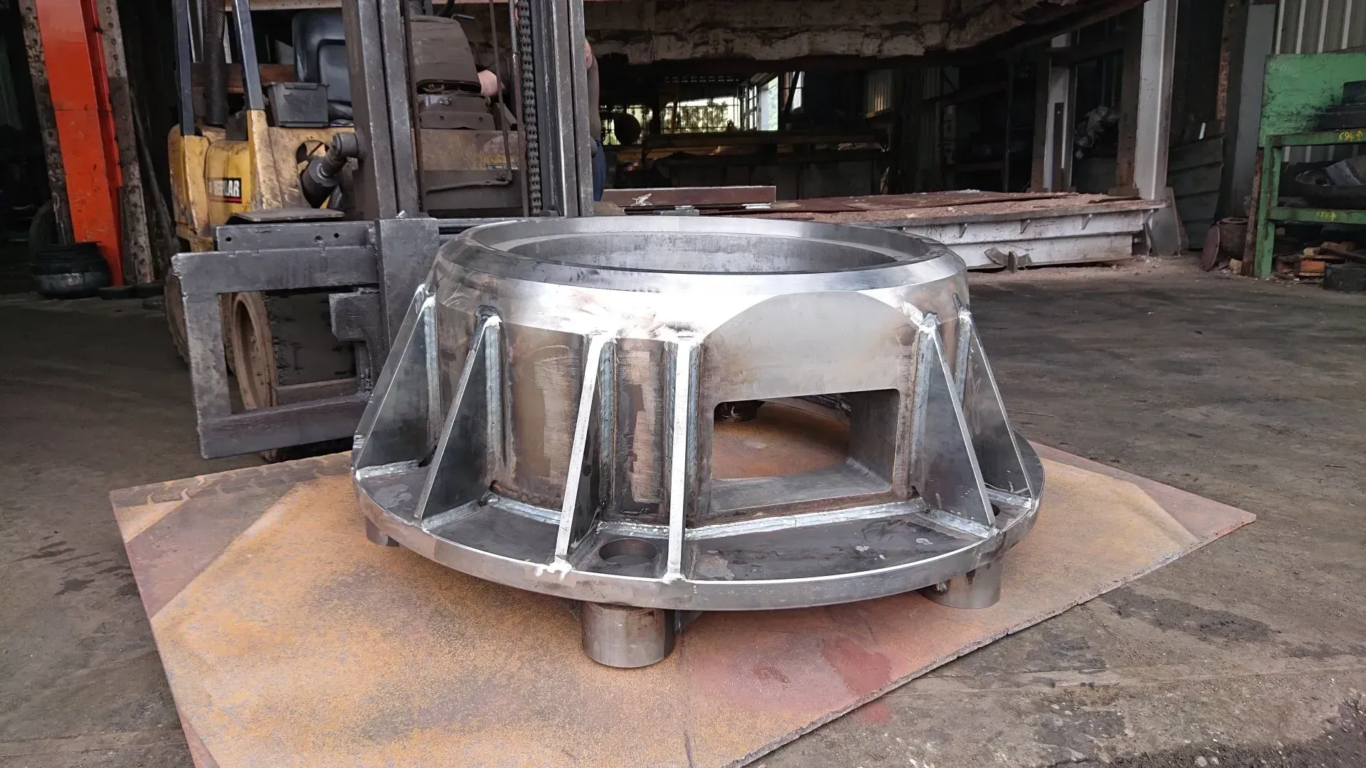 Pièce en métal posée au sol.