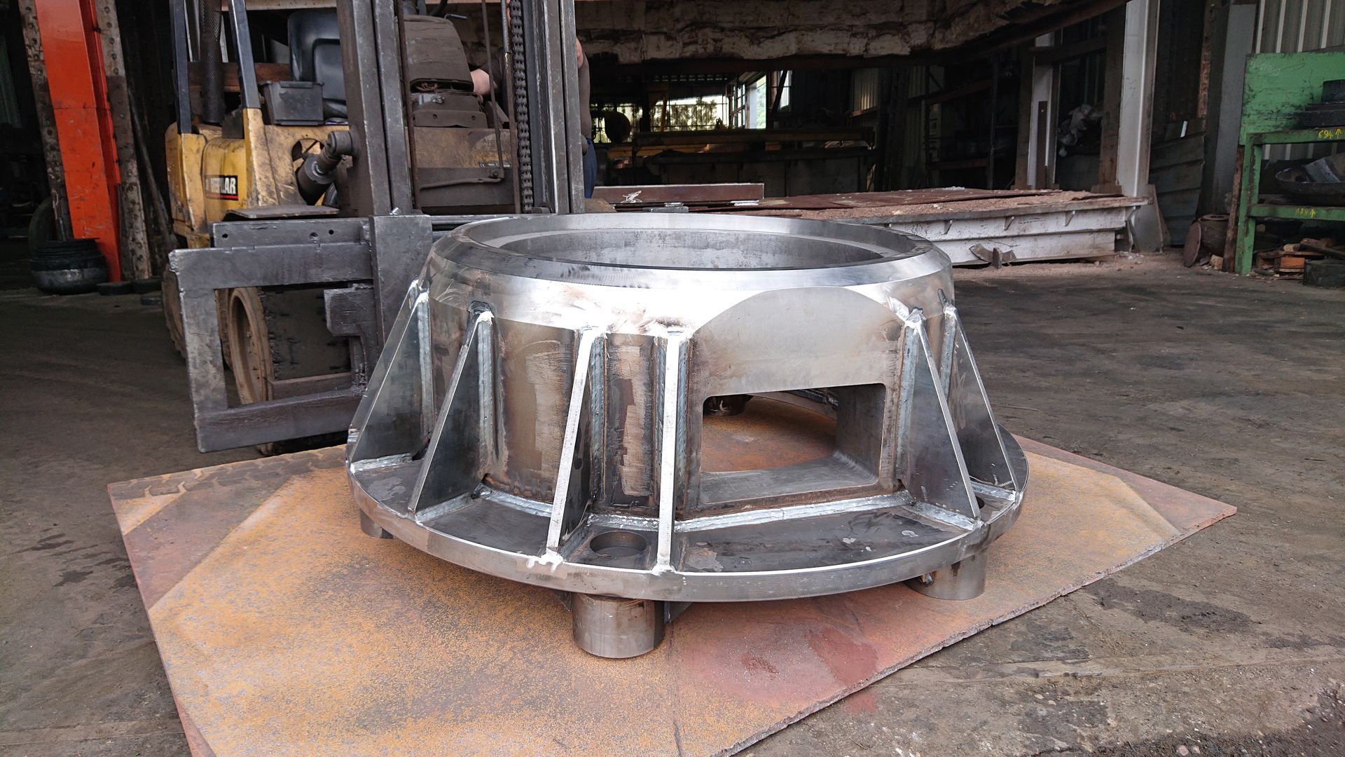 Carter d'alternateur posé sur une plaque dans un atelier.