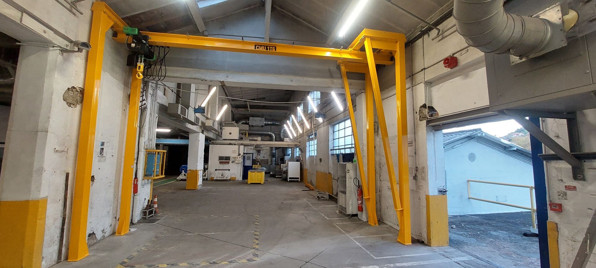 Pont roulant jaune dans un environnement industriel.