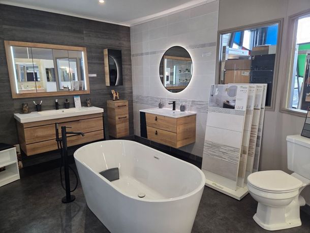 Exposition d'une salle de bains avec un bain, des toilettes et des vasques