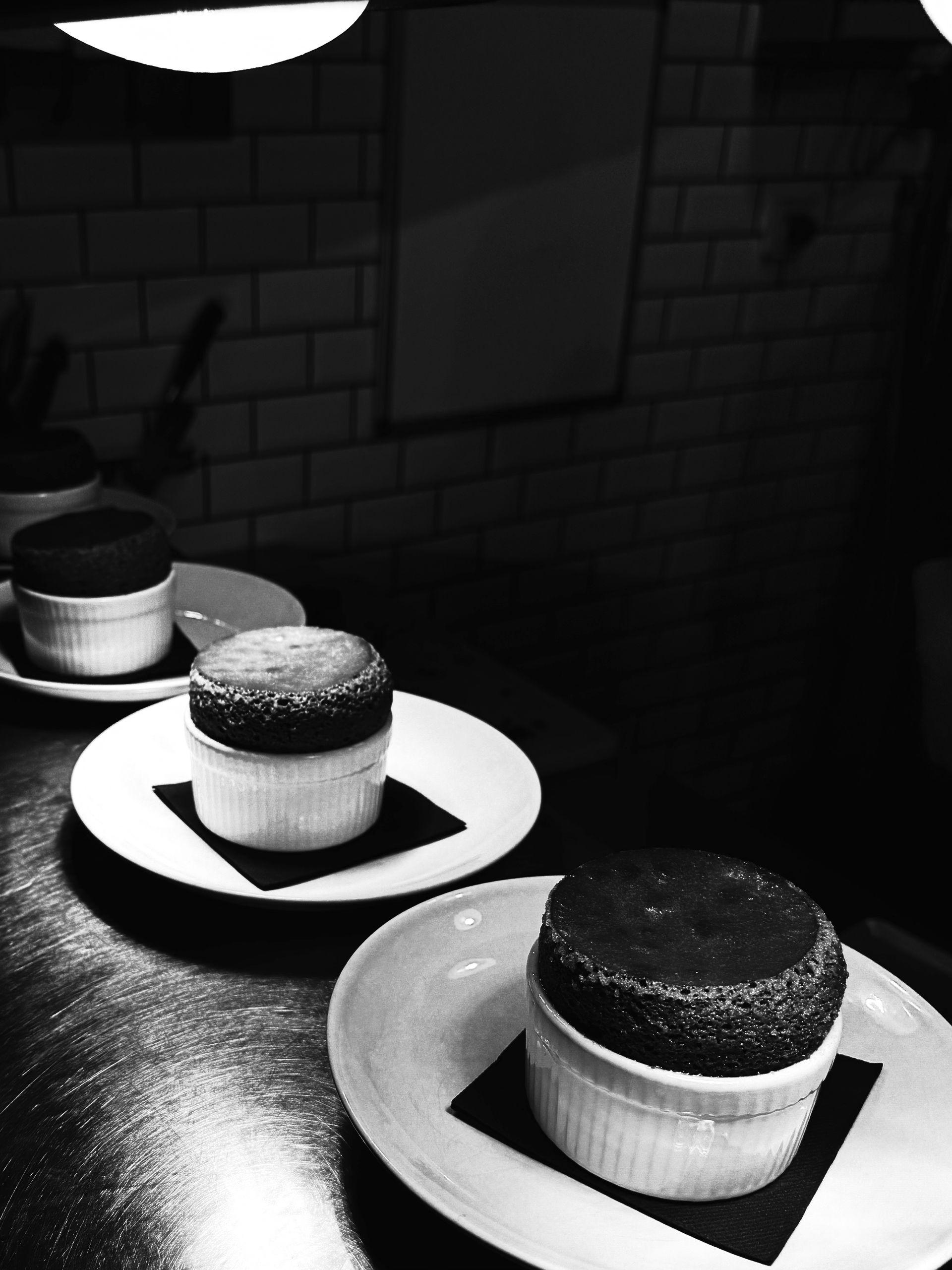 Un plat culinaire composé d'une base de chou-fleur jaune surmontée d'une mousse blanche crémeuse, de vermicelles colorés et d'herbes fraîches.