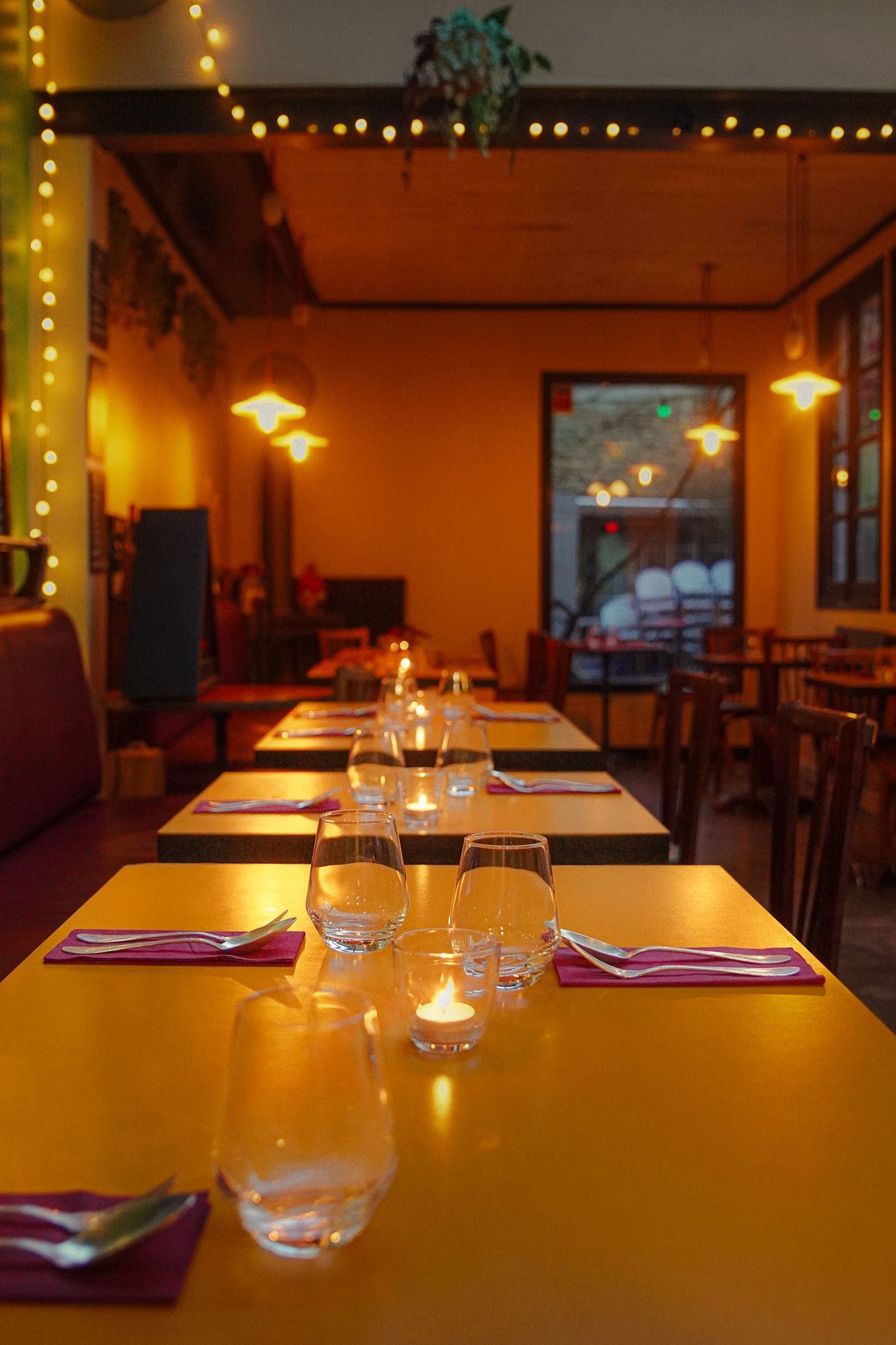 Un groupe de personnes partageant un dîner, verres à la main, souriant autour d'une table dans un lieu à l'éclairage tamisé.