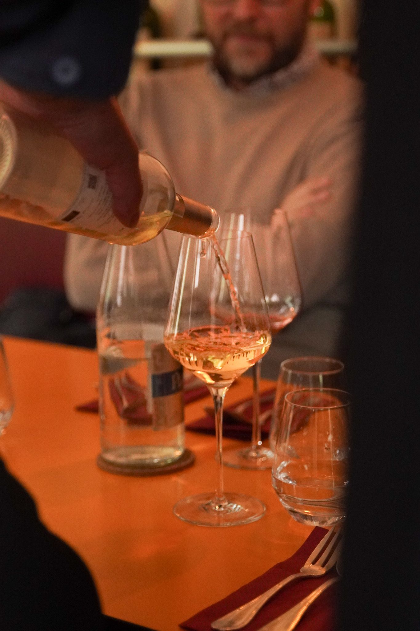 Un cocktail servi dans un verre à pied, avec une base liquide foncée et une mousse blanche épaisse, posé sur un sous-verre.