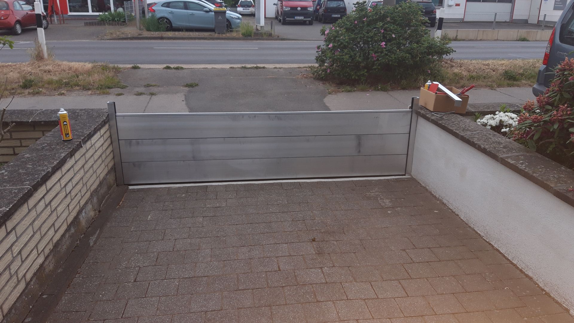 Ein gemauerter Gehweg mit einer Metallbarriere an der Seite