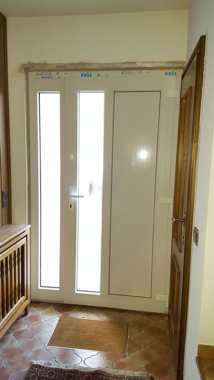 Ein weißes Fenster mit der Spiegelung einer Lampe darin.