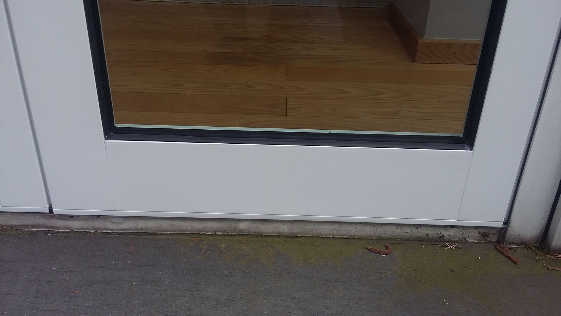 Eine Nahaufnahme eines weißen Fensters mit der Spiegelung einer Person darin.