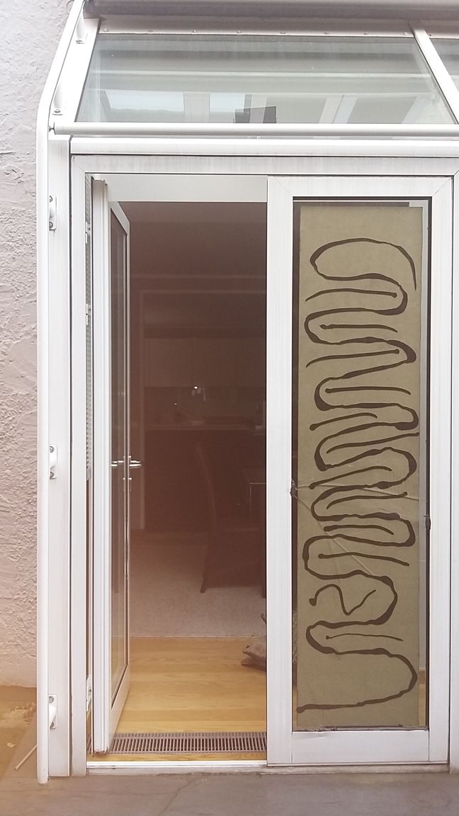 Ein zerbrochenes Fenster mit einer Spiegelung von Bäumen darin