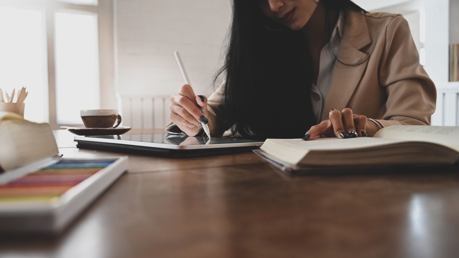 Una donna è seduta a un tavolo e usa un tablet.