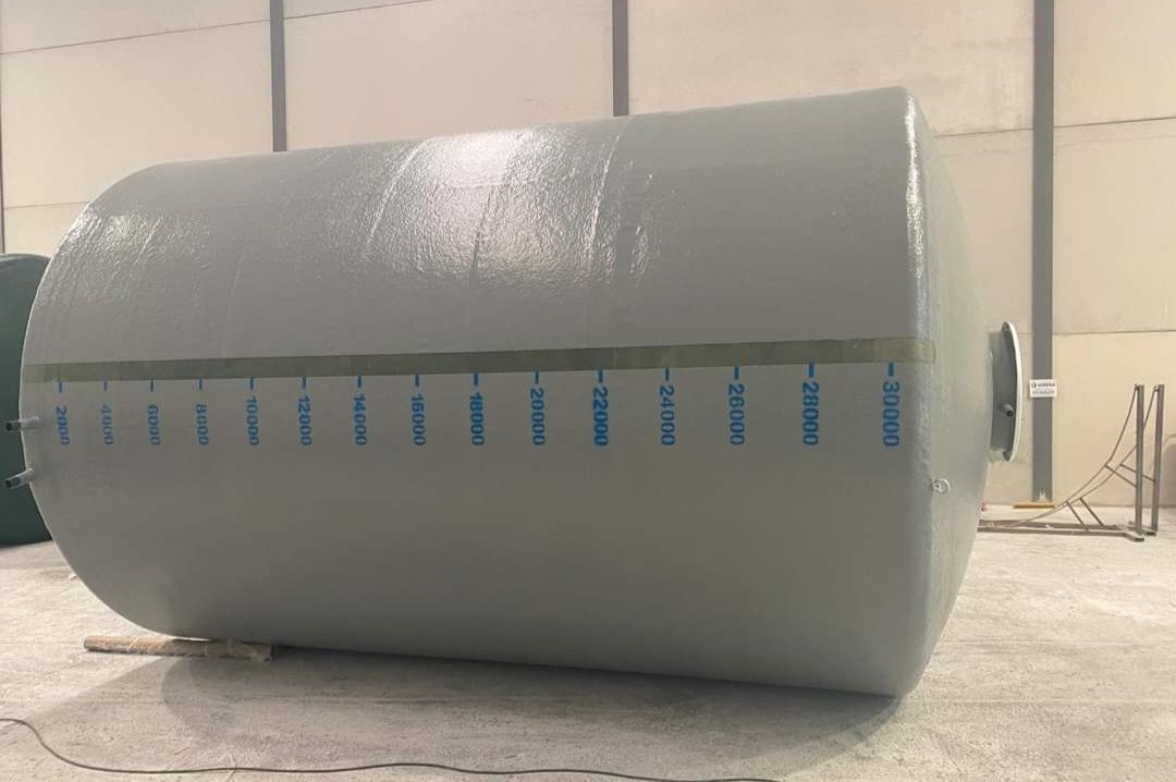 Un gran tanque gris está tirado en el suelo en un almacén.