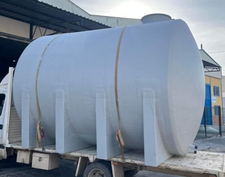 Un gran tanque blanco está sentado en la parte trasera de un camión.