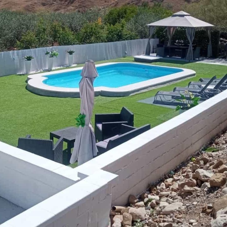 Una gran piscina rodeada de sillas y sombrillas.