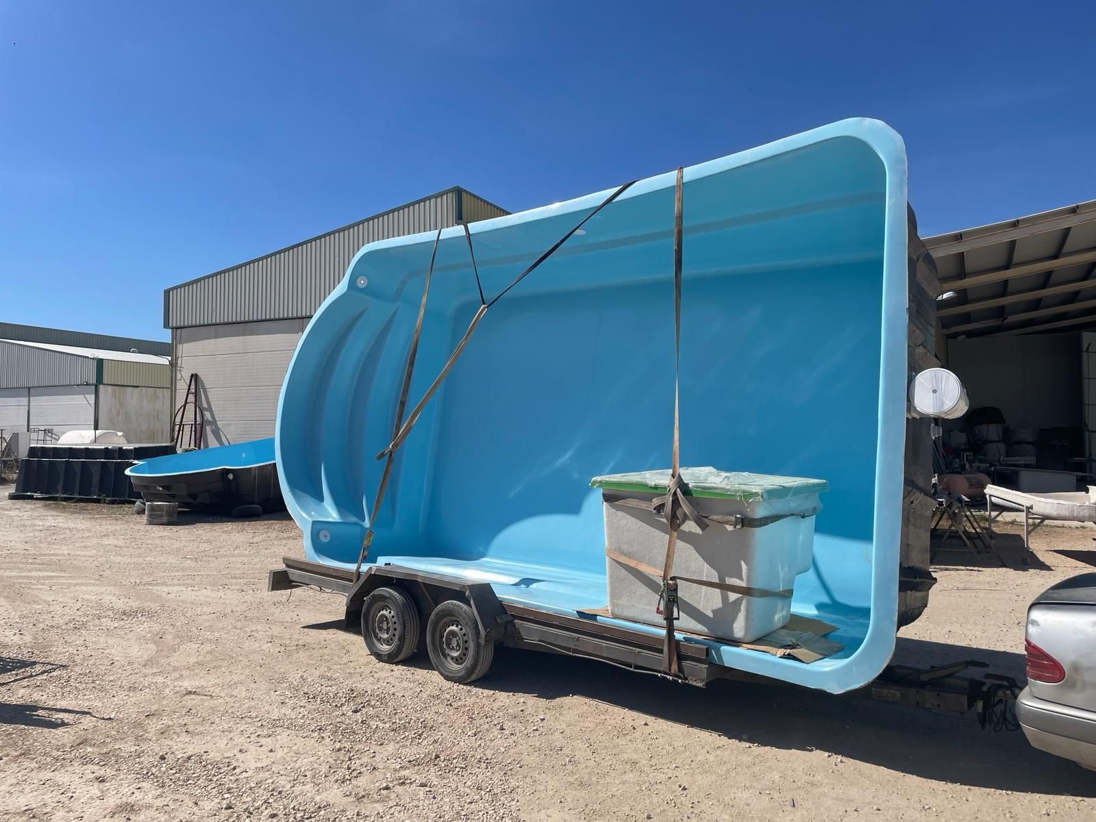 Una gran piscina azul está situada encima de un remolque.