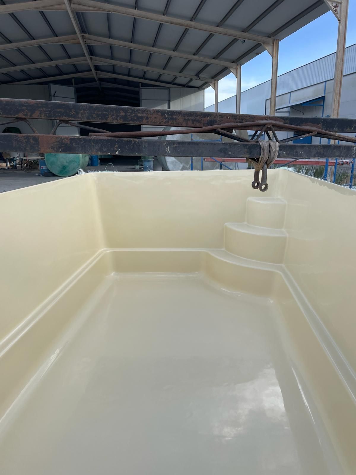 Una gran piscina blanca se encuentra bajo un techo en un almacén.