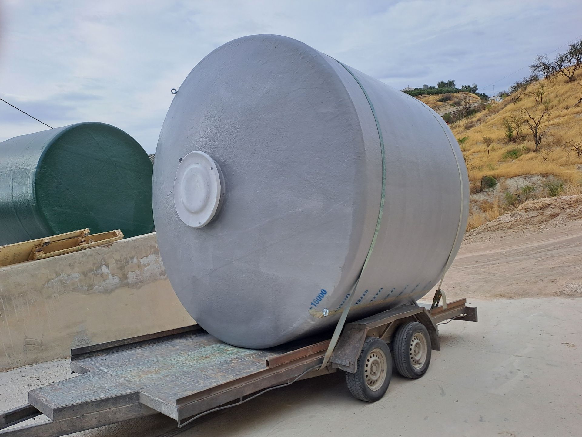 Un gran tanque gris está sentado encima de un remolque.