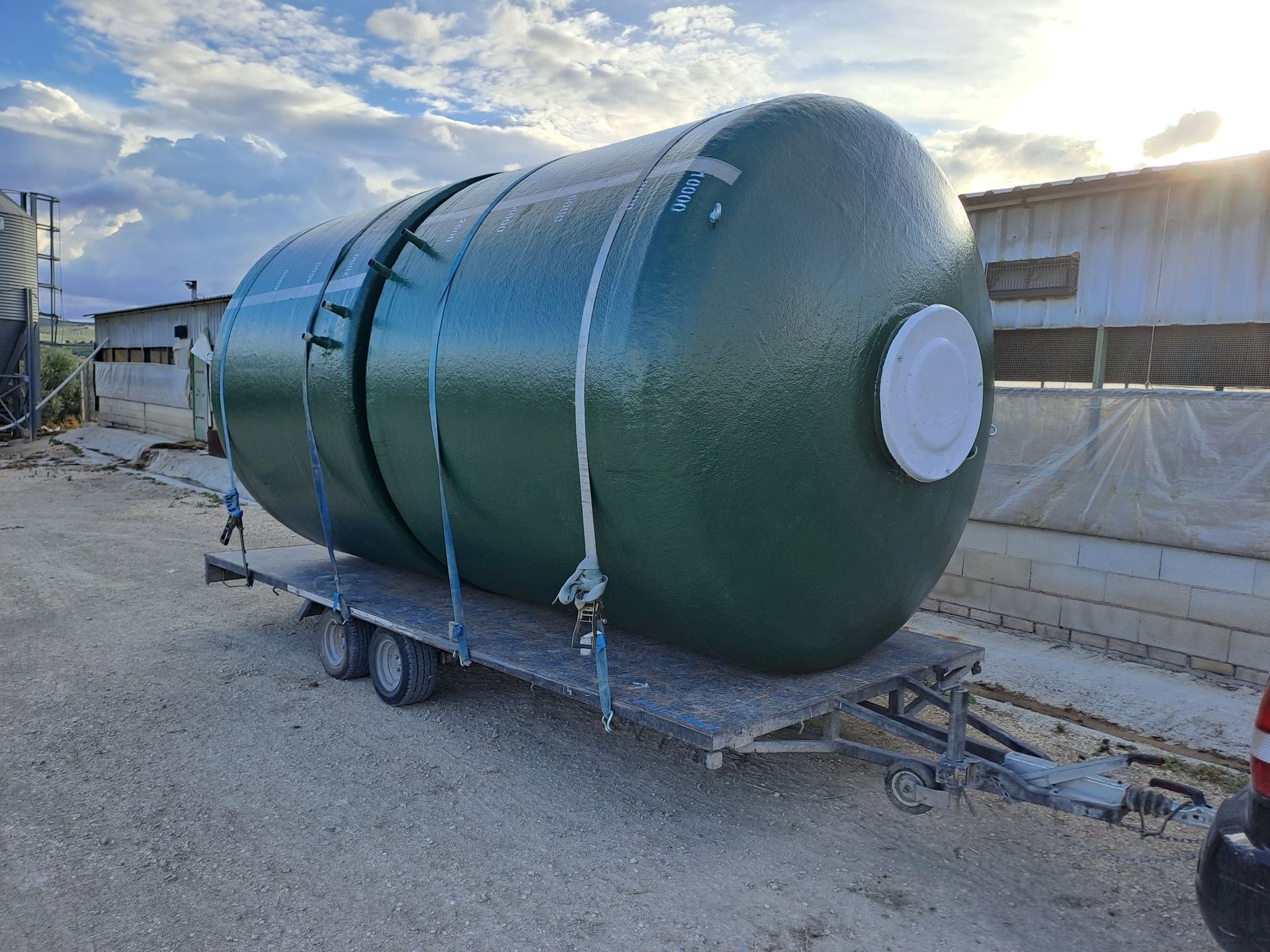 Un gran tanque verde está sentado encima de un remolque.